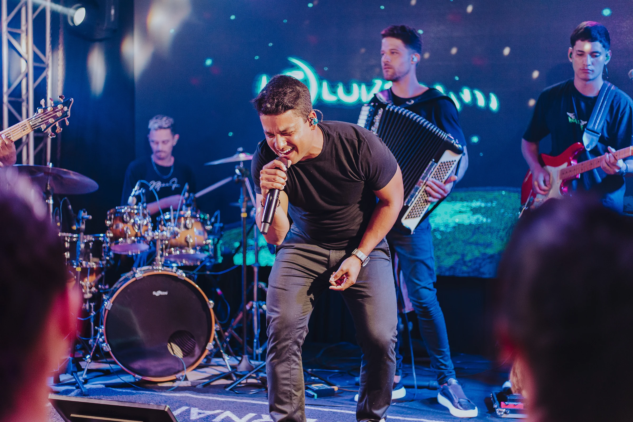 Luiz Fernando cantando no palco com a banda